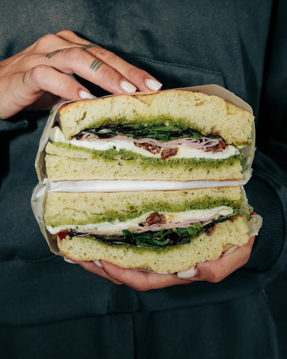 Sandwich au pesto tenu à deux mains, Klub à Saint-Raphaël